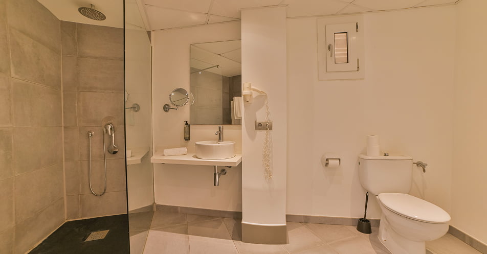 Badezimmer mit Dusche und Waschbecken auf einer Ablagefläche