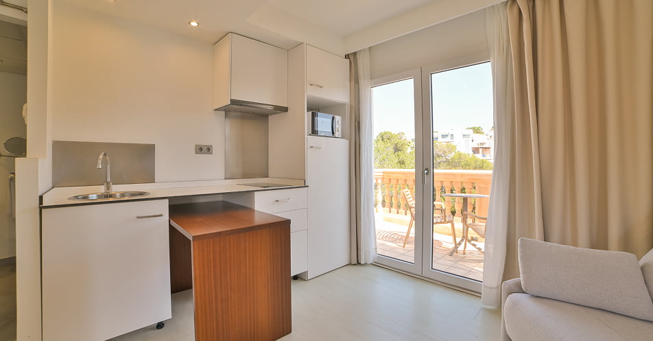 Küchenbereich mit Herd und Mikrowelle, mit Zugang zur Terrasse