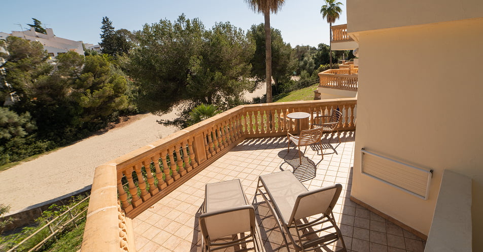 Große Terrasse mit Liegestühlen, Tisch und Stühlen und Blick auf den Strand und den Pinienwald