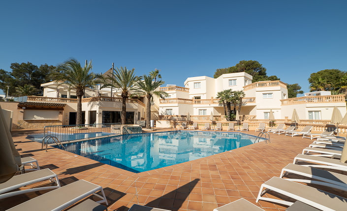 General view of the pool area, surrounded by sunbeds